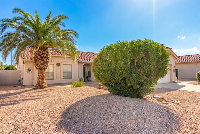 view of front of property with driveway, a tiled roof, an attached garage, and stucco siding