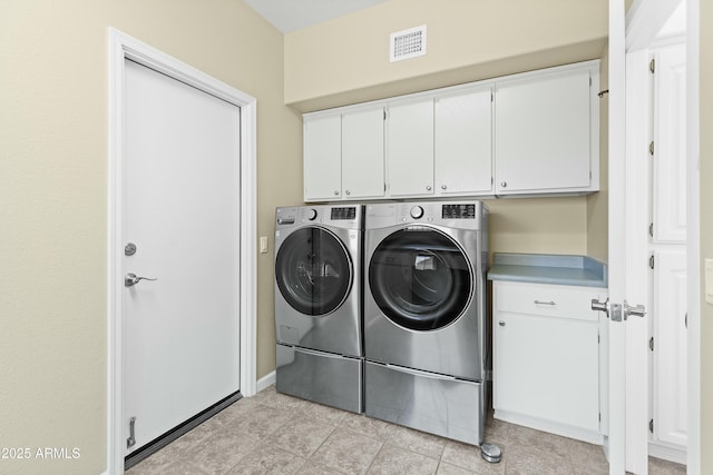 washroom with cabinets, light tile patterned floors, and independent washer and dryer