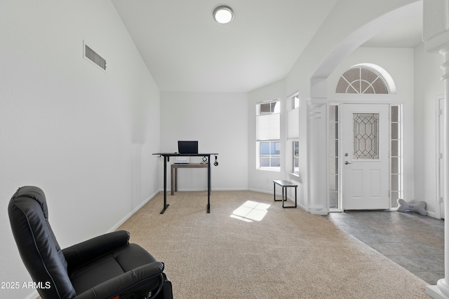 foyer entrance with a towering ceiling and carpet flooring