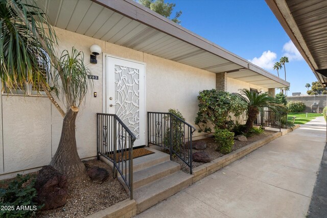 doorway to property featuring stucco siding