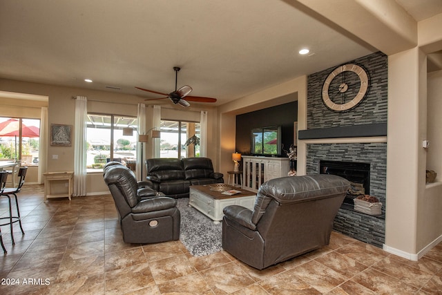 living room with a fireplace and ceiling fan