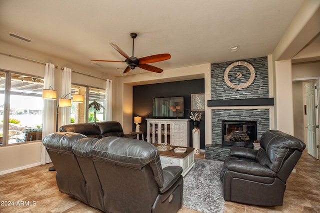 living room featuring ceiling fan, a fireplace, and a wealth of natural light