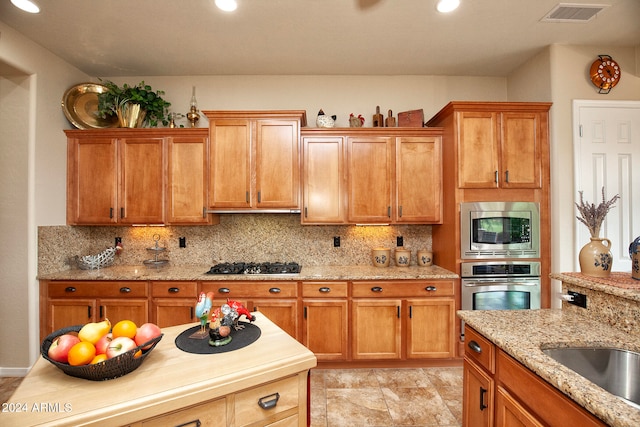 kitchen featuring light stone countertops, stainless steel appliances, and tasteful backsplash