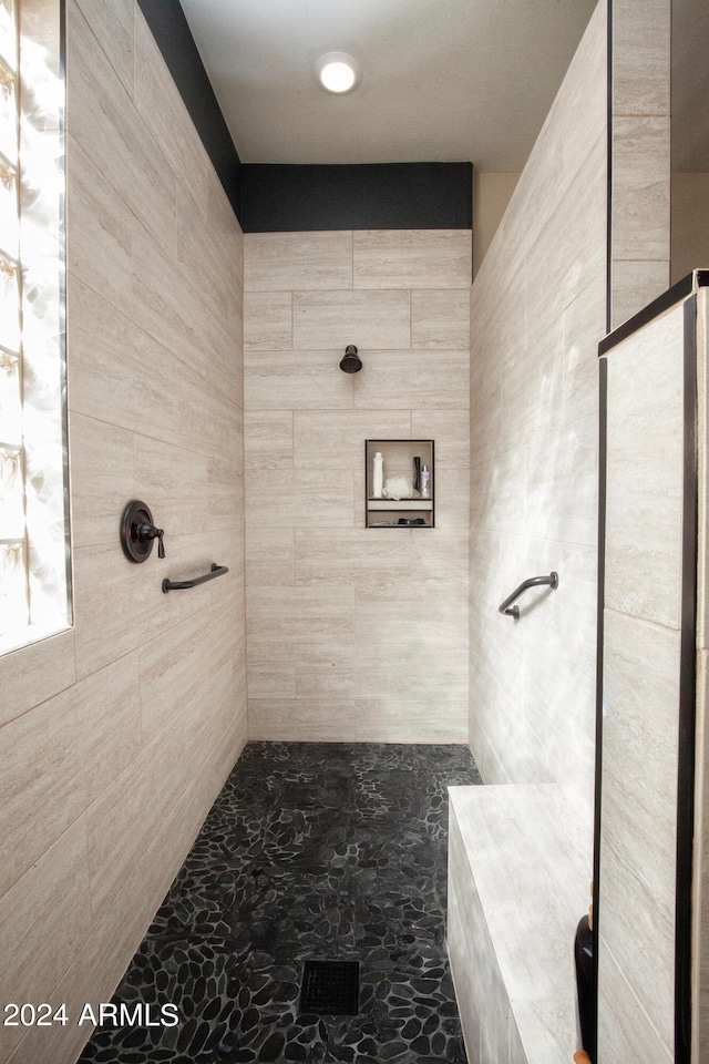 bathroom featuring tile walls and tiled shower