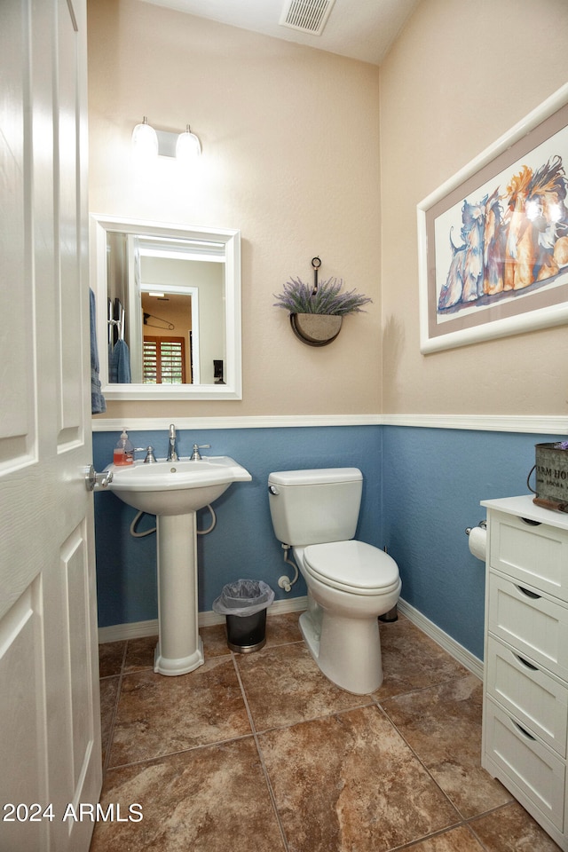 bathroom with toilet, tile patterned floors, and sink