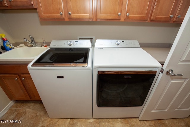 washroom featuring cabinets, sink, and separate washer and dryer