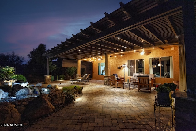 patio terrace at dusk featuring a pergola and ceiling fan