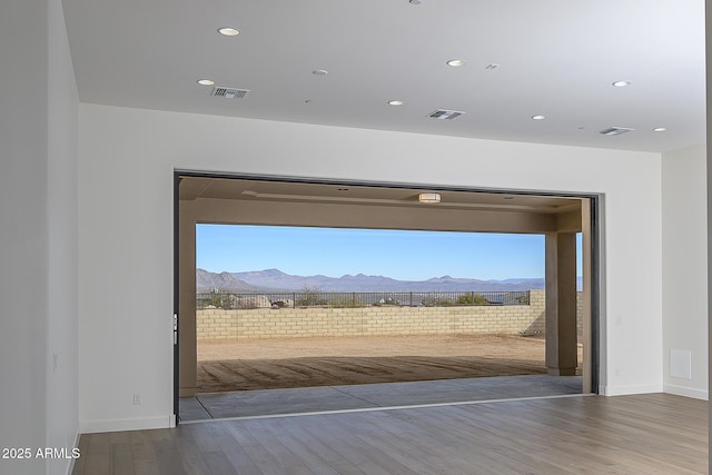 doorway with a mountain view, hardwood / wood-style floors, and a wealth of natural light