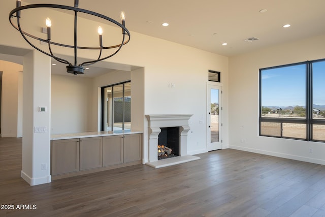 unfurnished living room featuring hardwood / wood-style flooring and a notable chandelier