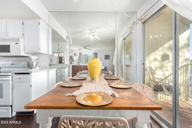 dining room featuring dark wood-type flooring, ceiling fan, a textured ceiling, and sink