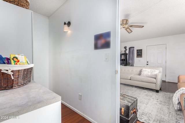 interior space with ceiling fan, a textured ceiling, and dark hardwood / wood-style flooring