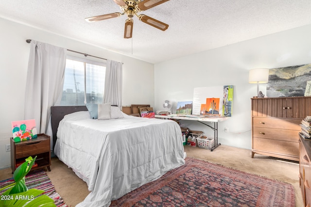 bedroom featuring light carpet, a textured ceiling, and ceiling fan