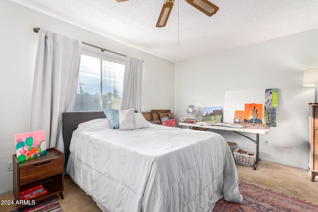 bedroom with ceiling fan, a textured ceiling, and carpet floors