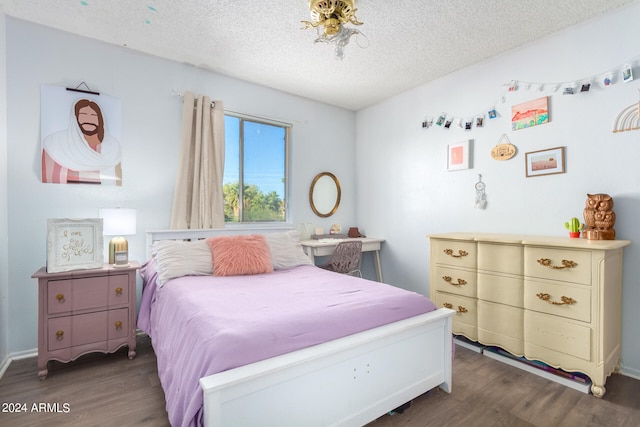 bedroom with dark wood-type flooring and a textured ceiling