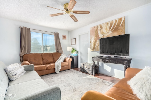 living room with a textured ceiling, hardwood / wood-style flooring, and ceiling fan