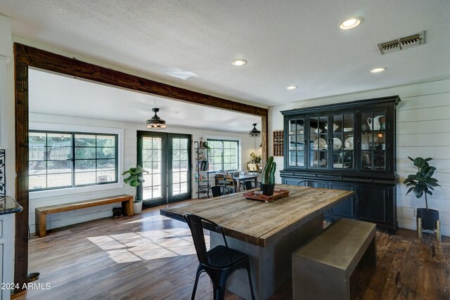 dining area featuring dark hardwood / wood-style floors, a textured ceiling, and a healthy amount of sunlight