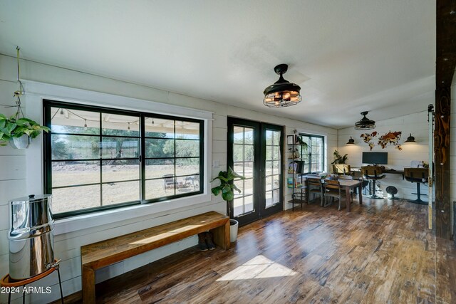 entryway featuring french doors, lofted ceiling, wood walls, and dark wood-type flooring