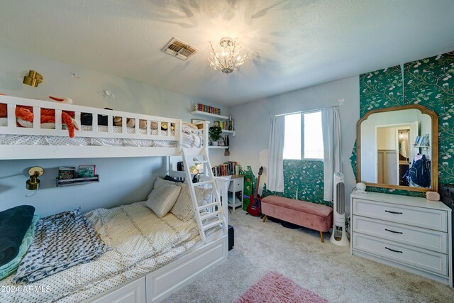 carpeted bedroom with a textured ceiling and a chandelier