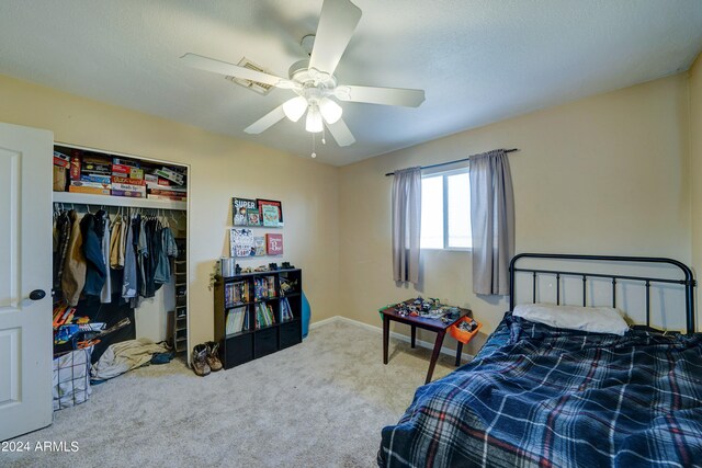 bedroom with ceiling fan, carpet floors, and a closet