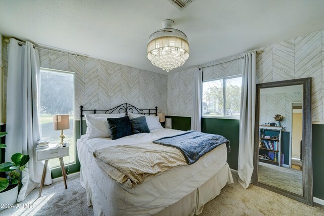 carpeted bedroom featuring a notable chandelier