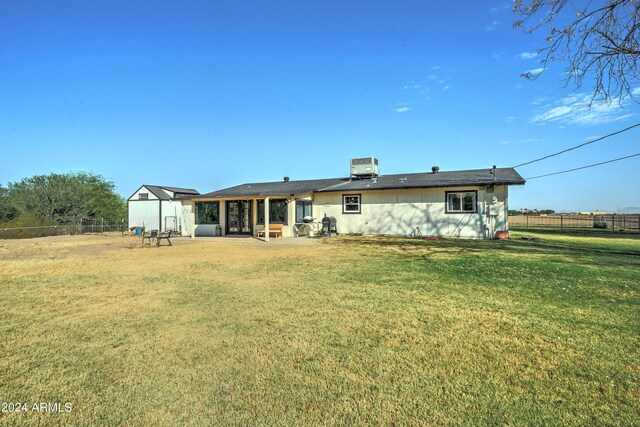 back of house featuring central AC, a yard, and a patio area