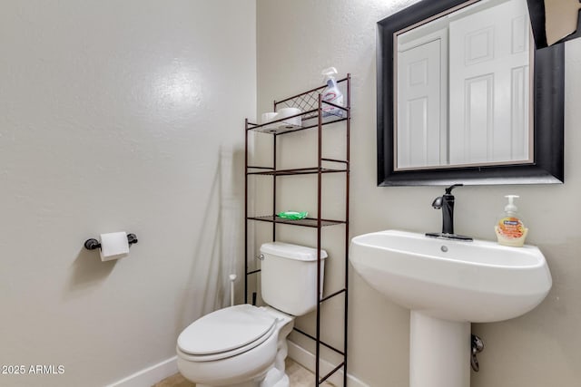 bathroom featuring toilet and baseboards