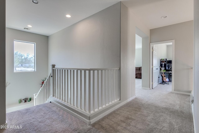 corridor featuring an upstairs landing, recessed lighting, visible vents, carpet floors, and baseboards