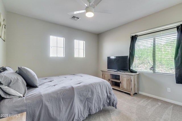 bedroom featuring light colored carpet, visible vents, baseboards, and a ceiling fan