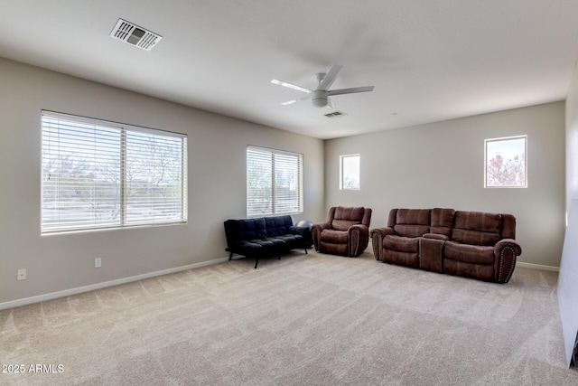 carpeted living area with ceiling fan, baseboards, and visible vents