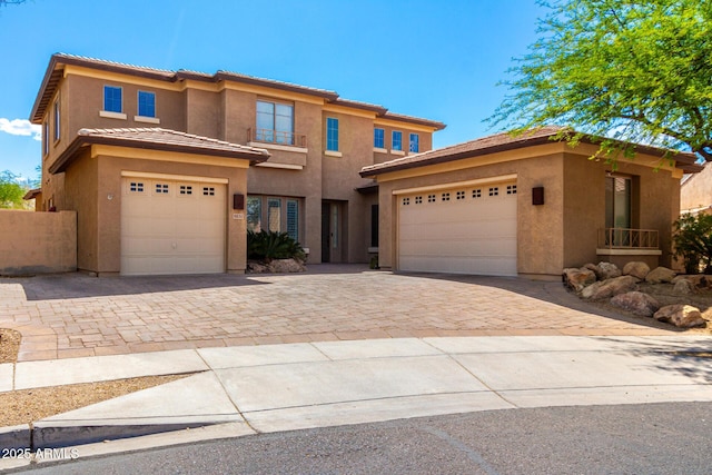prairie-style home with driveway, stucco siding, a tile roof, and an attached garage