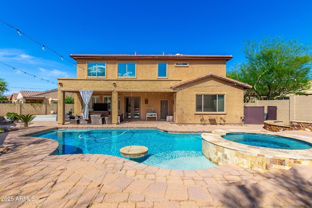 view of pool featuring a patio, a pool with connected hot tub, and a fenced backyard