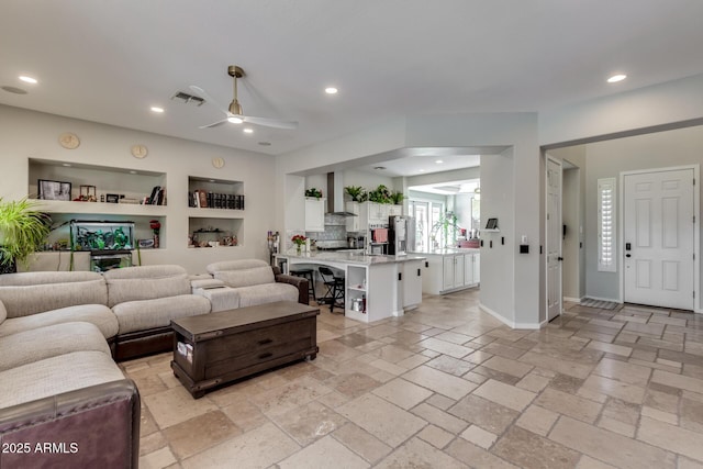 living area featuring stone tile flooring, visible vents, ceiling fan, and recessed lighting