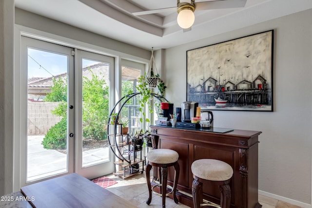 bar featuring a tray ceiling and ceiling fan