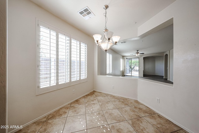 unfurnished dining area with arched walkways, visible vents, tile patterned flooring, and ceiling fan with notable chandelier