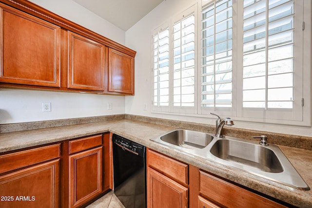 kitchen with a sink, light countertops, black dishwasher, and brown cabinets