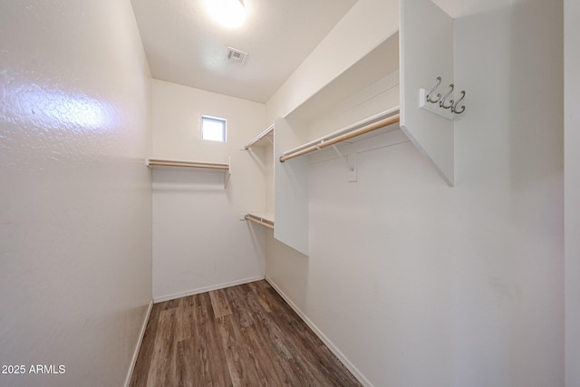 walk in closet with visible vents and wood finished floors