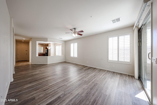 unfurnished living room featuring baseboards, ceiling fan, visible vents, and wood finished floors