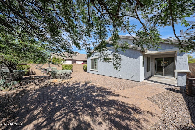back of property with a patio, stucco siding, and fence