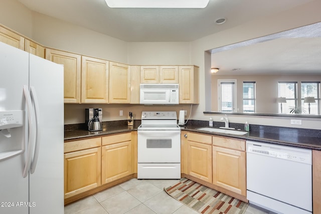 kitchen with light tile patterned flooring, white appliances, sink, and light brown cabinets