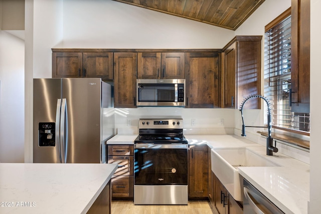 kitchen with a sink, wood ceiling, vaulted ceiling, dark brown cabinets, and appliances with stainless steel finishes