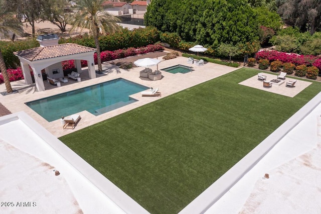 pool featuring a lawn, a gazebo, a hot tub, and a patio area