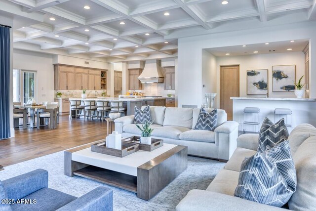 living room with beam ceiling, wood finished floors, recessed lighting, and coffered ceiling