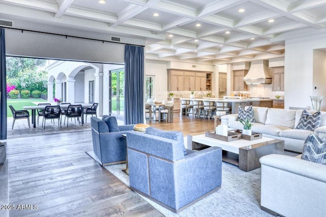 living room with a wealth of natural light, visible vents, recessed lighting, and decorative columns