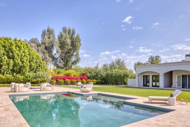 outdoor pool featuring a lawn and a patio area