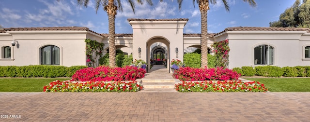mediterranean / spanish-style house featuring stucco siding and a front yard