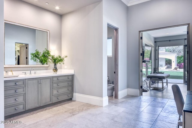 bathroom with recessed lighting, a bidet, vanity, baseboards, and crown molding