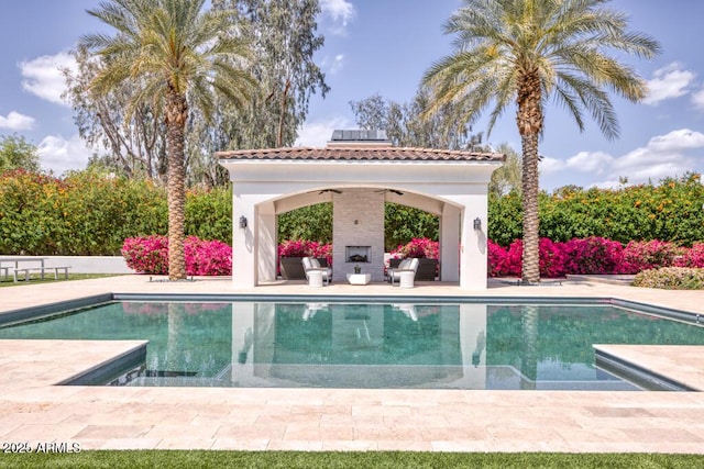 outdoor pool featuring a gazebo, a ceiling fan, a patio, and a fireplace