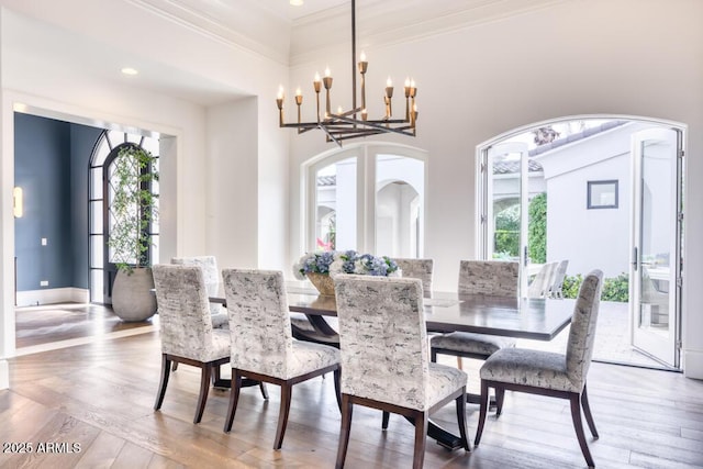 dining space with crown molding, arched walkways, an inviting chandelier, and plenty of natural light