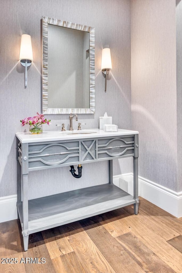 details with wood finished floors, vanity, and baseboards