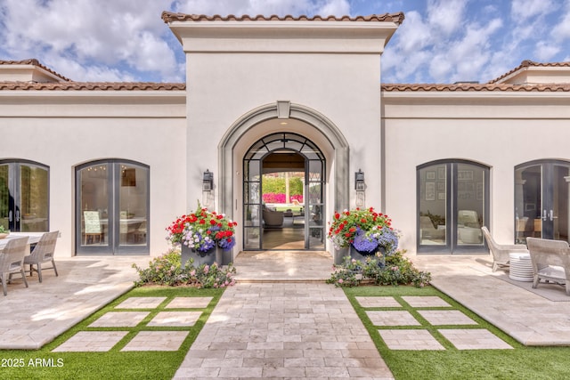 property entrance with stucco siding and french doors